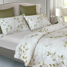 Load image into Gallery viewer, Duvet cover set with green leaf pattern on bed with matching shams