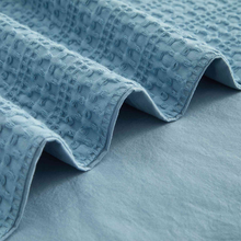Load image into Gallery viewer, Close-up of folded blue waffle-weave duvet cover fabric
