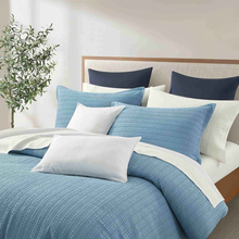Load image into Gallery viewer, Blue textured duvet cover set with matching shams on bed
